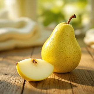 A hyperrealistic close-up of a ripe green pear with a golden blush, its glossy skin illuminated by soft afternoon light, with a slice revealing juicy white flesh and tiny seeds. The background is a blurred wooden surface, evoking a serene, spa-like atmosphere for a candle fragrance note.