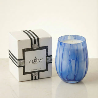 Azure Coastal Bliss – Feng Shui Water Element luxury soy candle in artisan blue marbled glass next to premium black-ribbon GLORY STRENGTH gift packaging