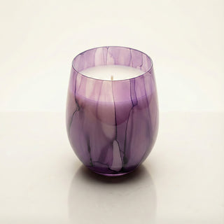 Enigmatic Bloom Feng Shui wood element luxury candle in hand-painted purple marbled glass vessel on clean ivory background